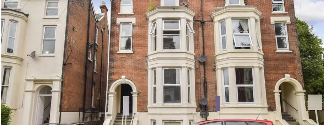 The bay-fronted Victorian terrace from the street, brick and render with arched entrances