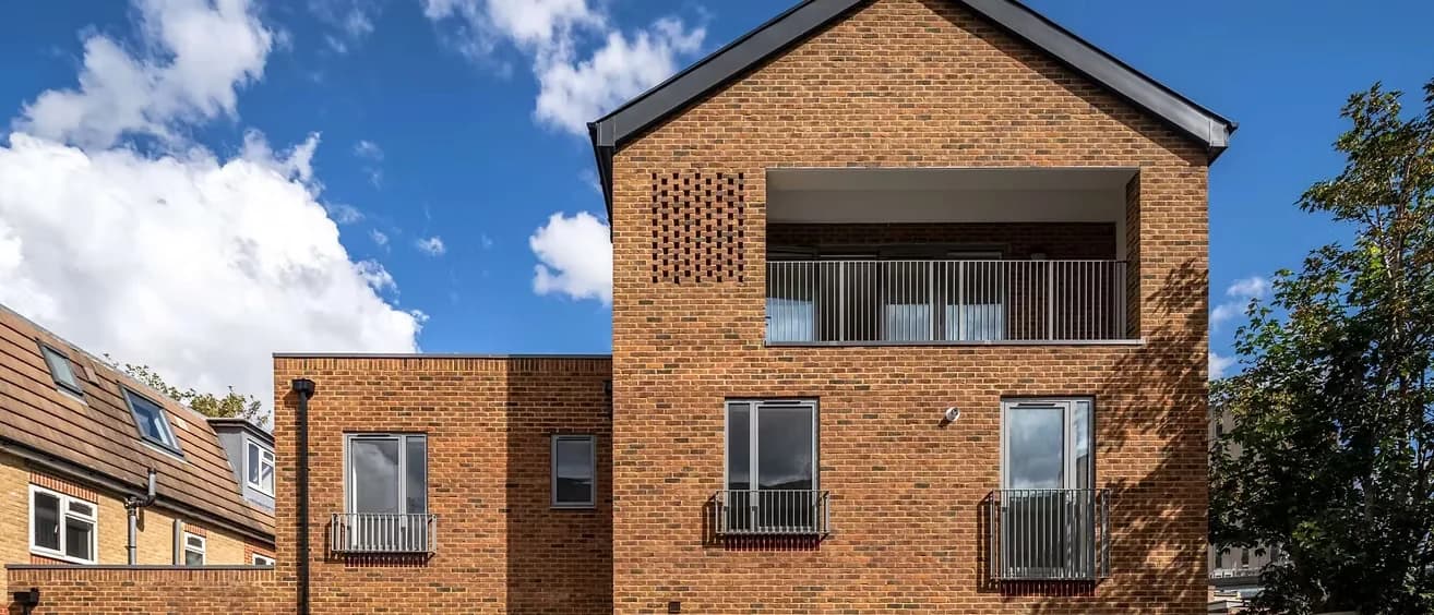 Upper storey with a recessed balcony behind a perforated brick screen