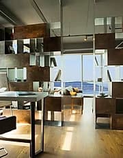 Warm timber and glass living interior opening onto a sea view